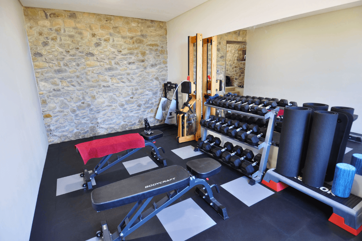 Dalles PVC Fortelock Invisible grises et noires installées dans une salle de sport, créant un sol résistant et esthétique.