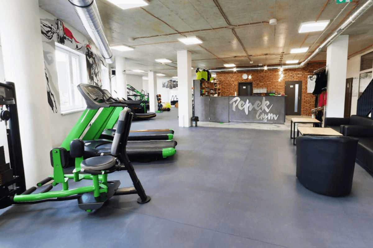Dalles PVC Fortelock XL graphite installées dans une salle de fitness moderne.