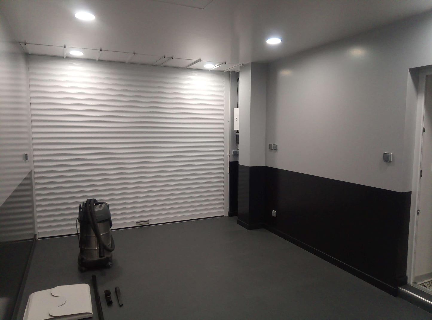 Dalles PVC Fortelock Invisible graphite installées dans un garage. Les queues d'aronde invisibles créent un sol uniforme et élégant.