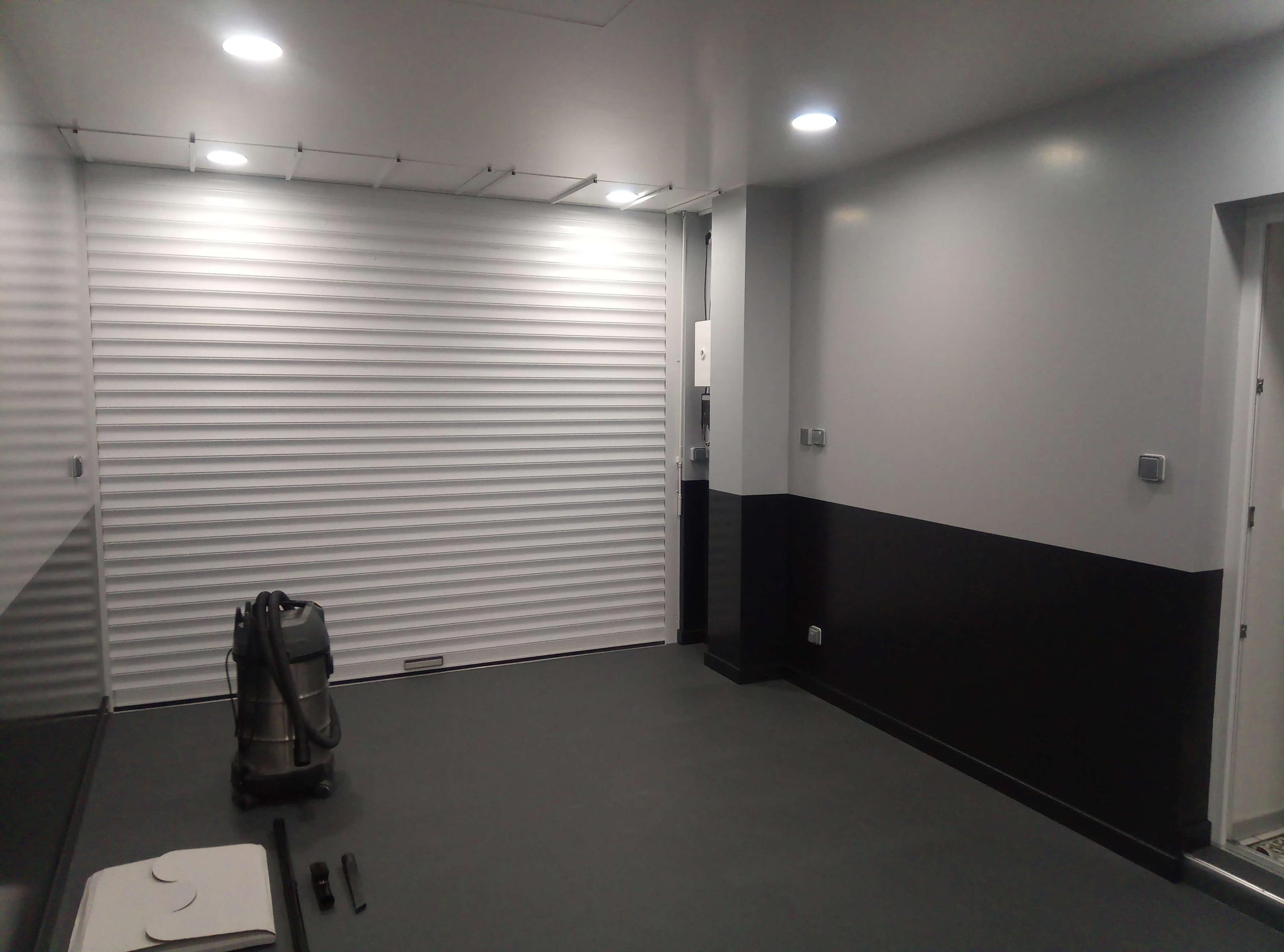 Dalles PVC Fortelock Invisible graphite installées dans un garage. Les queues d'aronde invisibles créent un sol uniforme et élégant.