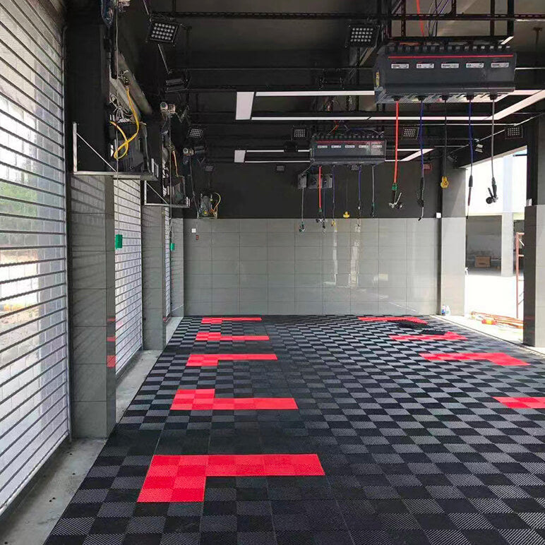 Dalles perforées AERO noires avec marquage rouge dans un atelier