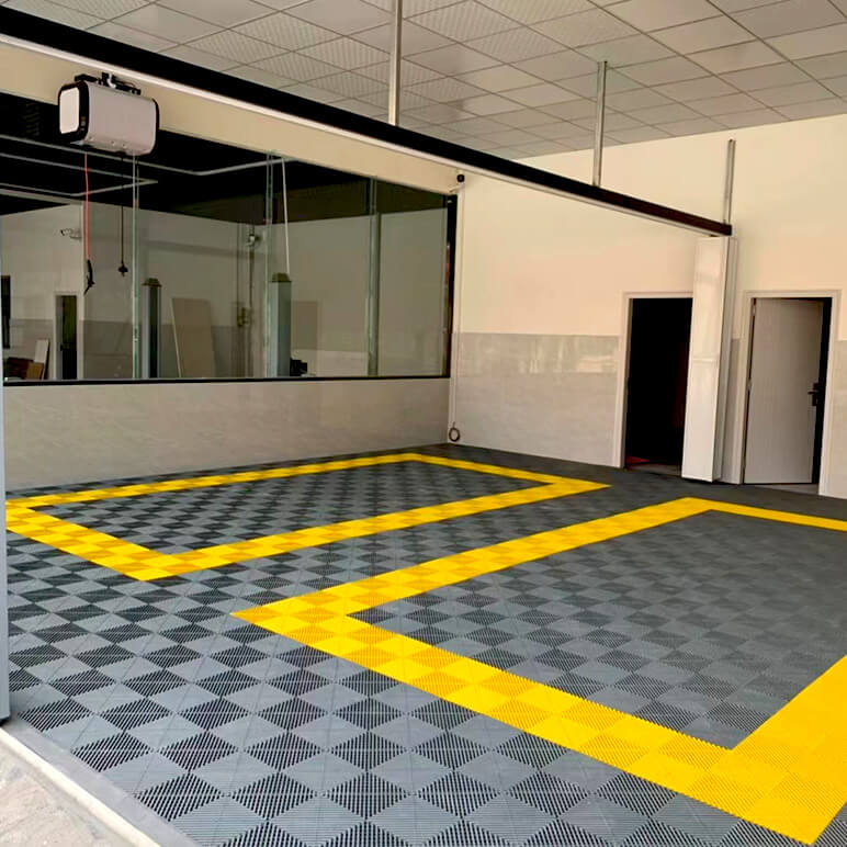 Dalles perforées AERO grises avec délimitation jaune dans un local professionnel