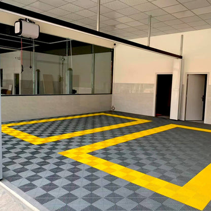 Dalles perforées AERO grises avec délimitation jaune dans un local professionnel