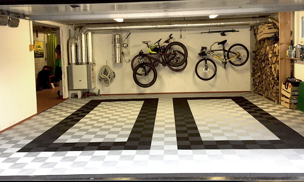 Dalles perforées AERO noires et blanches dans un garage avec vélos