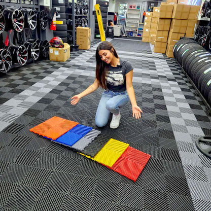 Dalles perforées AERO grises et dalles de couleur dans un entrepôt de pneus